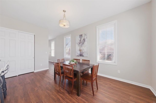 dining space featuring dark wood-style floors and baseboards