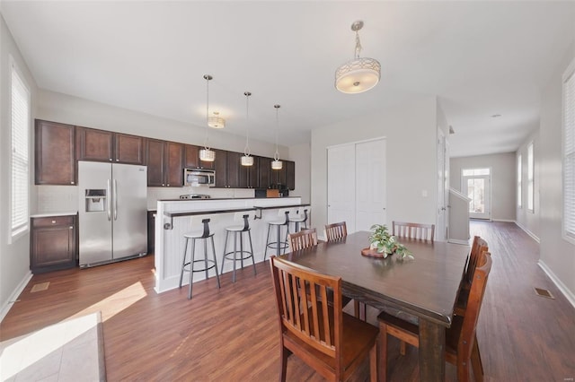 dining area with baseboards and wood finished floors