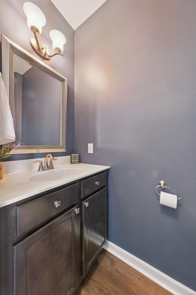 bathroom featuring baseboards, wood finished floors, and vanity