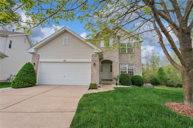 traditional home featuring brick siding, driveway, an attached garage, and a front yard