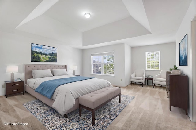 bedroom featuring baseboards, light colored carpet, and a tray ceiling