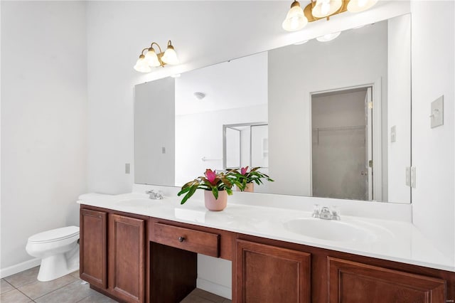 bathroom with toilet, double vanity, a sink, and tile patterned floors
