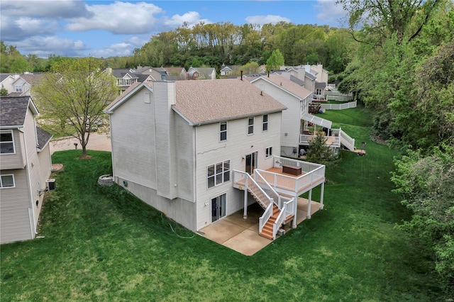 back of property with a patio, a wooden deck, a lawn, and stairs