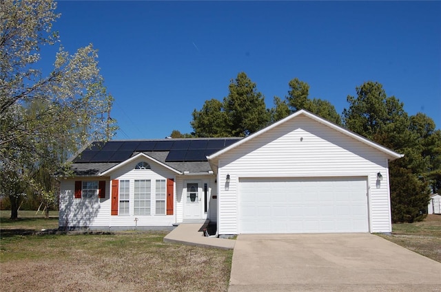 ranch-style house with a front lawn, driveway, solar panels, and an attached garage