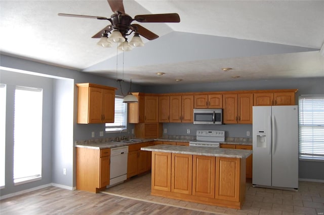 kitchen featuring white appliances, light countertops, a wealth of natural light, and a kitchen island