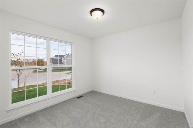 spare room with baseboards, visible vents, and carpet flooring