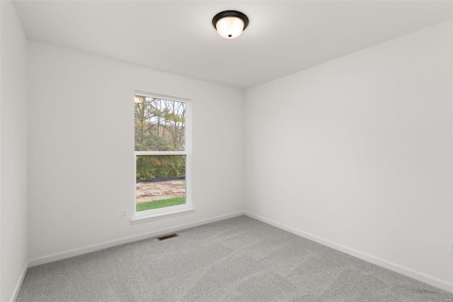 spare room with baseboards, carpet floors, and visible vents