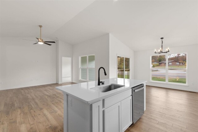 kitchen featuring lofted ceiling, a sink, light wood-type flooring, open floor plan, and stainless steel dishwasher