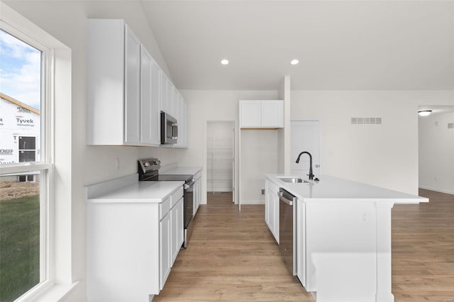 kitchen featuring a sink, white cabinetry, appliances with stainless steel finishes, light wood-type flooring, and visible vents