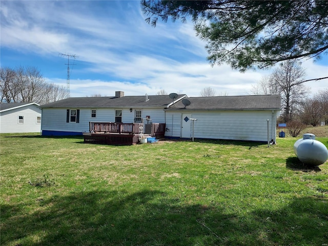 back of property with a yard and a wooden deck