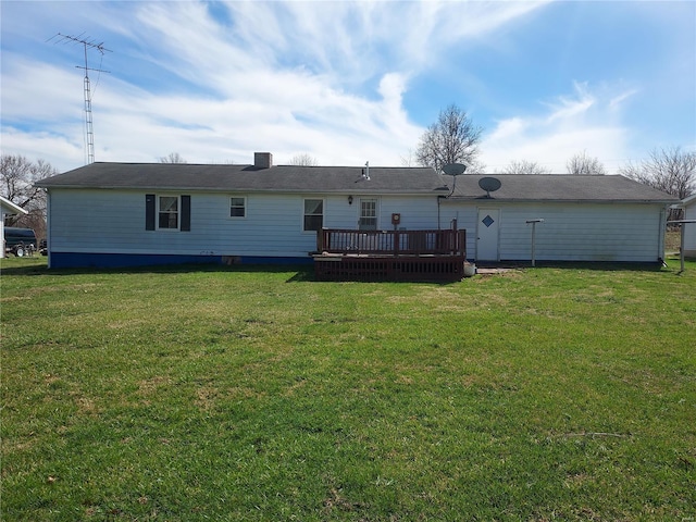 rear view of property with a wooden deck, a yard, and a chimney