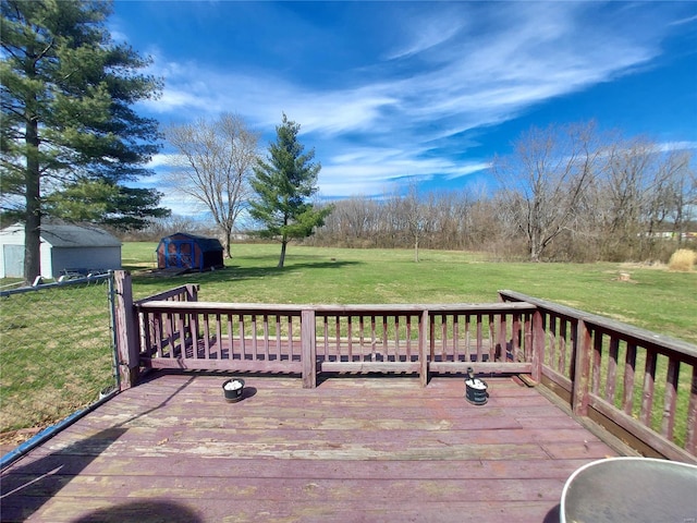 wooden terrace featuring a lawn, an outbuilding, and a shed