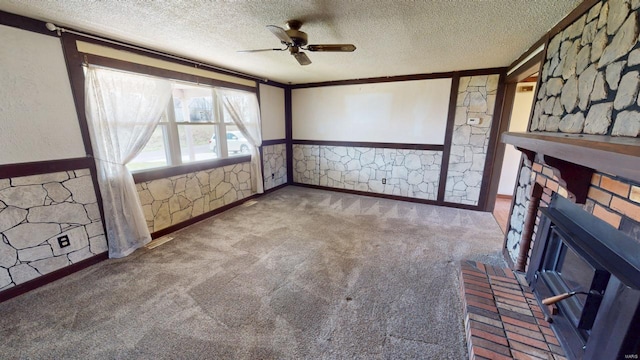 unfurnished living room with ceiling fan, a fireplace, and a textured ceiling