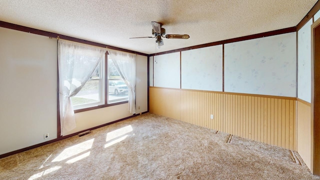 spare room with a ceiling fan, a textured ceiling, visible vents, and carpet