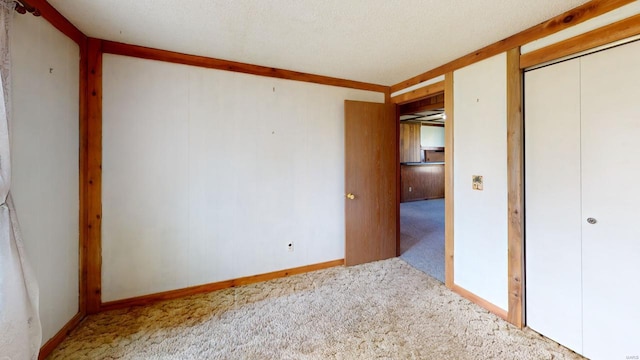 unfurnished bedroom featuring a closet, baseboards, and carpet flooring