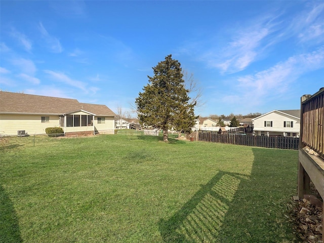 view of yard with a residential view, a sunroom, and fence