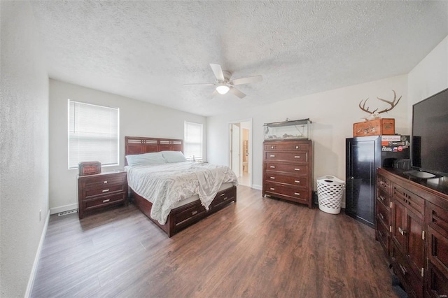 bedroom featuring a textured ceiling, a ceiling fan, baseboards, and dark wood-style flooring