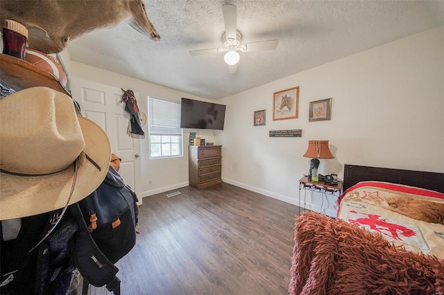 bedroom featuring a textured ceiling, baseboards, ceiling fan, and wood finished floors