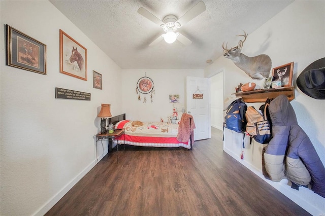 bedroom with dark wood-style floors, ceiling fan, baseboards, and a textured ceiling