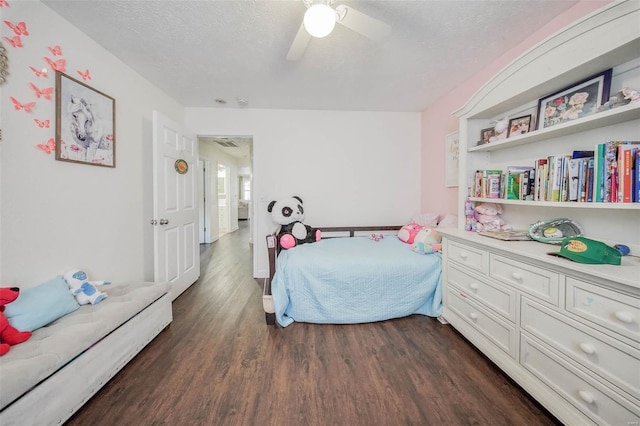 bedroom featuring a ceiling fan, visible vents, a textured ceiling, and dark wood finished floors