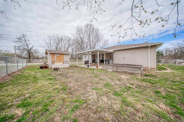 back of property featuring a fenced backyard, a lawn, an outdoor structure, and a patio area