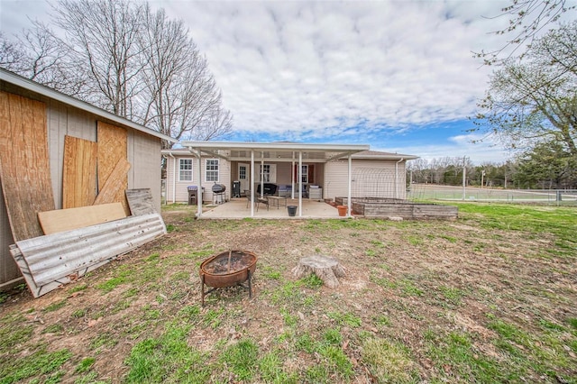 rear view of house with a fire pit, fence, and a patio