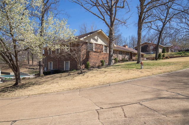 view of front facade featuring brick siding and a front lawn