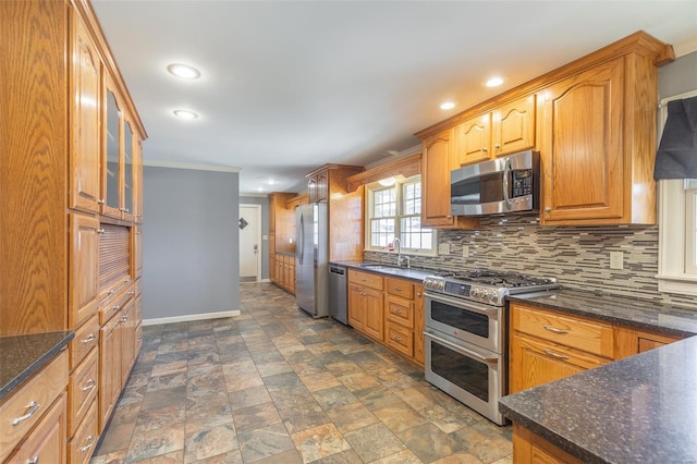 kitchen featuring crown molding, backsplash, appliances with stainless steel finishes, glass insert cabinets, and baseboards