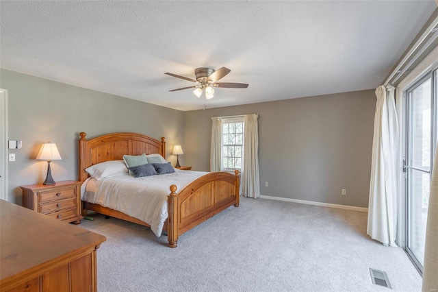 bedroom with baseboards, a textured ceiling, a ceiling fan, and light carpet