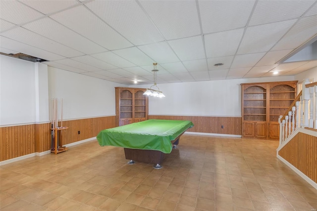 game room featuring a drop ceiling, a wainscoted wall, and wooden walls
