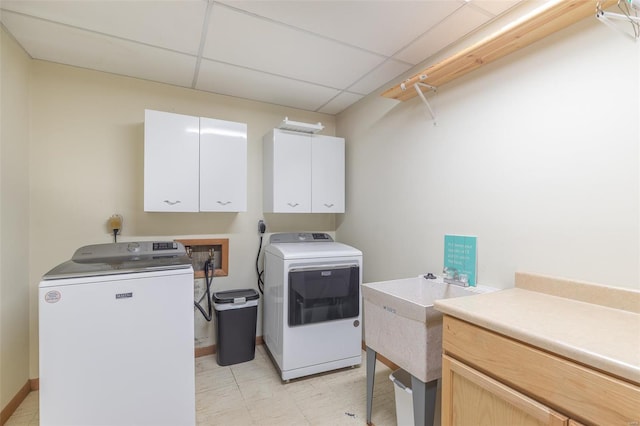 laundry room featuring baseboards, cabinet space, and independent washer and dryer