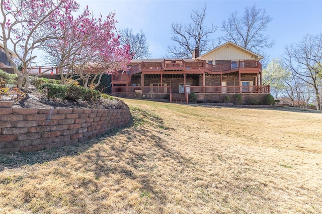rear view of house with a yard, a chimney, and a deck