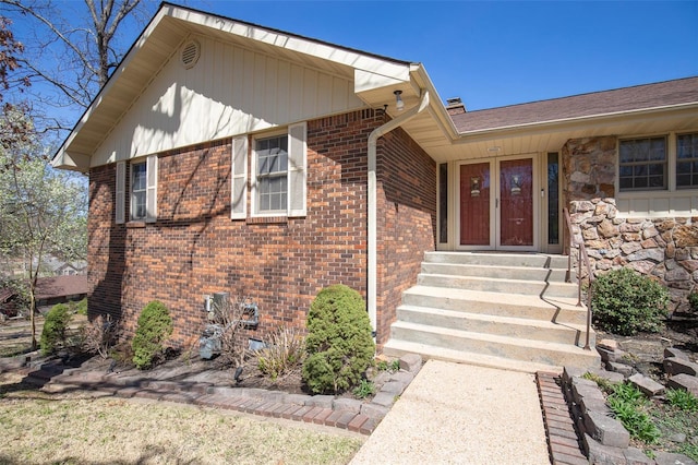 view of exterior entry featuring brick siding