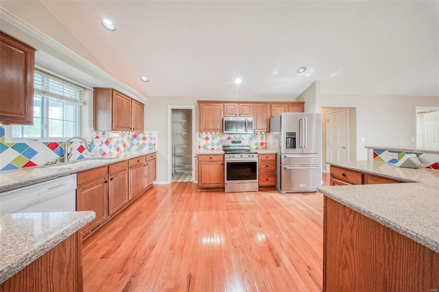 kitchen featuring light wood-style floors, recessed lighting, a sink, appliances with stainless steel finishes, and backsplash