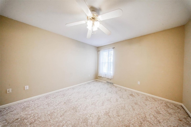 carpeted spare room featuring ceiling fan, visible vents, and baseboards
