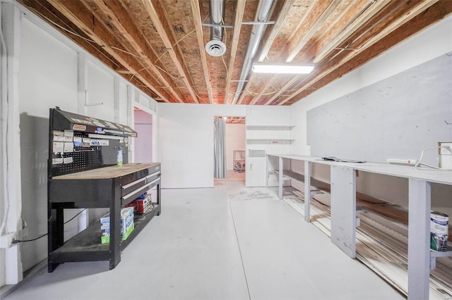 unfinished basement featuring a workshop area