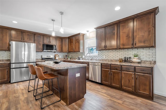kitchen with backsplash, stainless steel appliances, and wood finished floors