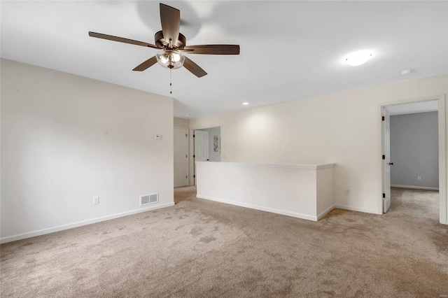 empty room featuring visible vents, a ceiling fan, baseboards, and carpet floors