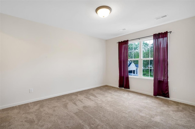 unfurnished room with carpet flooring, baseboards, and visible vents