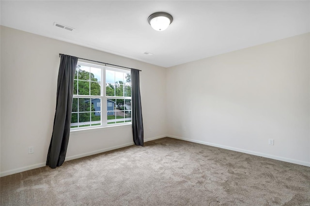 carpeted empty room with baseboards and visible vents