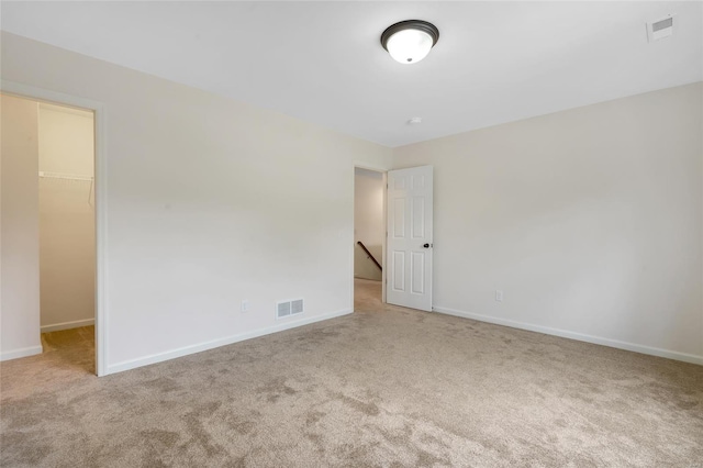carpeted spare room featuring baseboards and visible vents