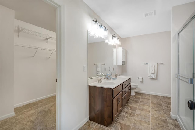 bathroom with double vanity, a sink, a spacious closet, and a shower stall