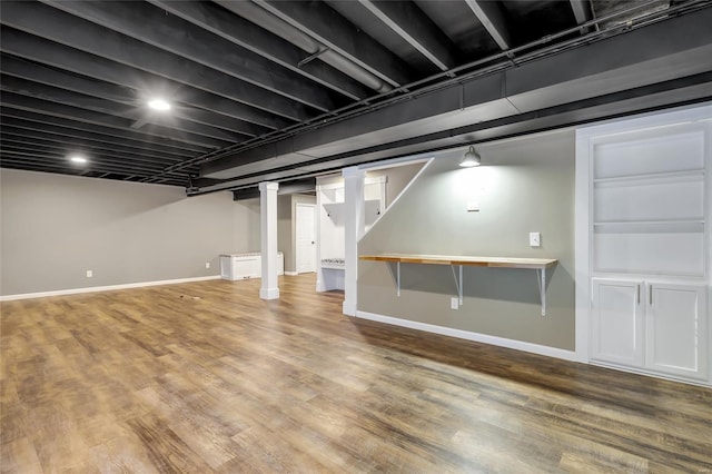 finished below grade area featuring baseboards and wood finished floors