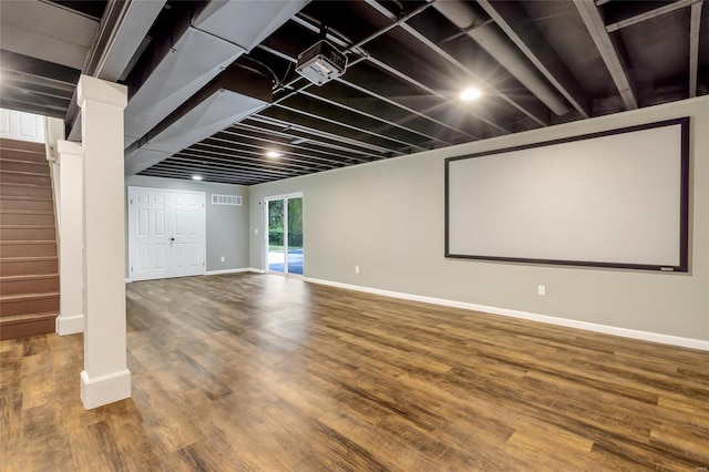 cinema room featuring baseboards, wood finished floors, and visible vents