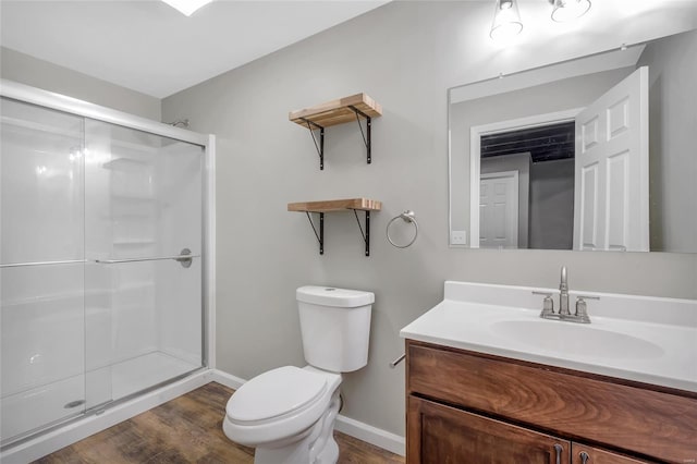 bathroom with wood finished floors, a stall shower, toilet, and vanity