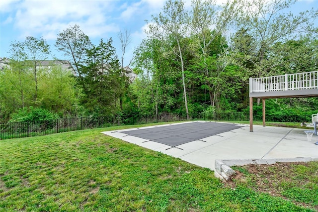view of swimming pool featuring a patio, a fenced backyard, a wooden deck, and a yard