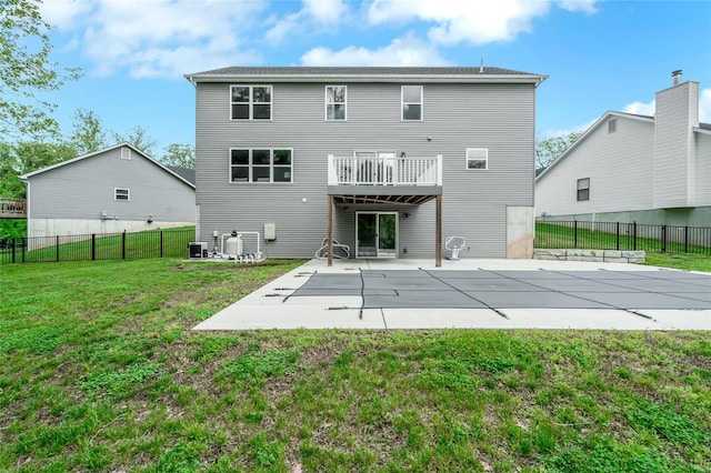 back of house featuring a patio, fence, a yard, and a fenced in pool