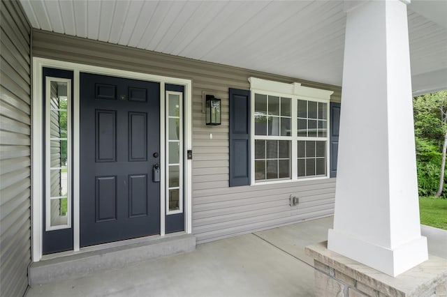 view of exterior entry featuring covered porch