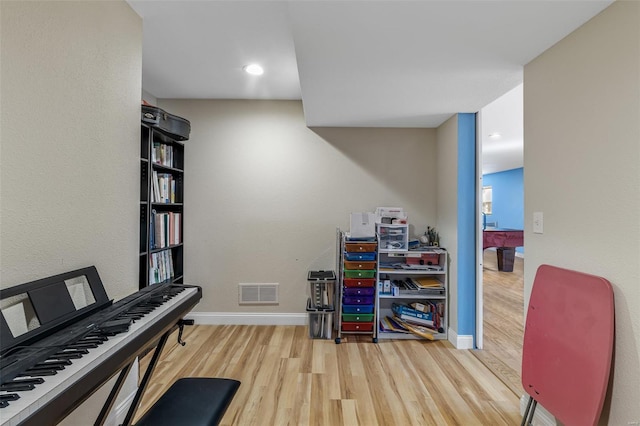 interior space with baseboards, visible vents, and wood finished floors