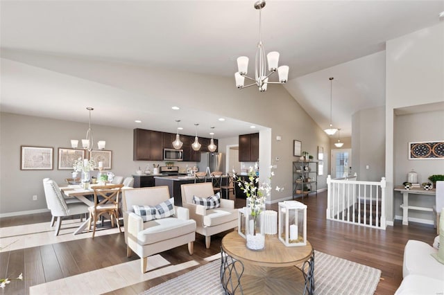 living area with baseboards, high vaulted ceiling, wood finished floors, and a chandelier